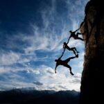 partnership through trust, climbers helping each other on a mountain