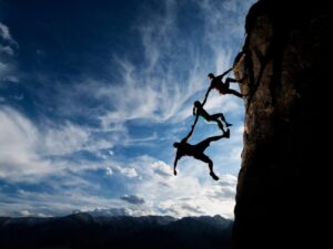 partnership through trust, climbers helping each other on a mountain
